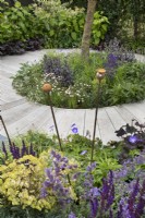 Circular path intersecting beds of perennials in 'Here We Go Round The Mulberry Bush' garden at BBC Gardener's World Live 2019, June