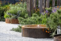 Corten steel water feature on a gravel path surface