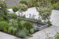 Metal water feature and flowerbeds in 'The Home Solutions by John Lewis Garden' at BBC Gardeners World Live 2019