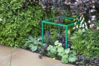 Mixed planting with decorative green metal cube in 'The Macmillan Legacy Garden' at BBC Gardeners World Live 2019, June