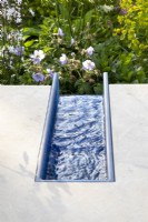 A modern contemporary water rill made from recycled plastics set in polished stone 