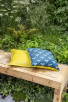 Cushions with bee print on a wooden outdoor bench