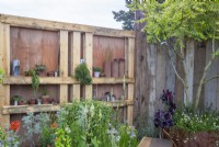 Garden fence made from salvaged reclaimed timber scaffolding boards and wooden pallets used as shelves and drought tolerant planting - Punk Rockery Garden 