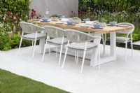 Outdoor dining table and chairs on a white stone paved patio - mixed perennial planting of Lupins and Monarda flowers, Lower Barn Farm: The Bounce Back Garden