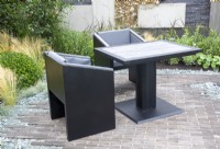 Brick paved patio area with black table and chairs