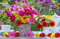 Sumer flower bouquets in milk jug and tin can vase containing Cosmos, Dahlia, Helianthus, Clematis seedheads and Fennel.