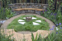 Curved dry stone wall with wooden seat in The 'Mandala' Mindfulness garden at RHS Chatsworth Flower Show 2019, June