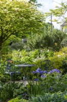 Elegant metal garden furniture in shady spot in summer garden