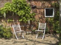 Rustic wooden chairs in cottage courtyard