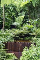Corten steel water feature in middle of lush planting