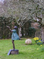 Bronze metal garden scupture 'Matilda'  in an orchard at RHS Rosemoor, February. 
