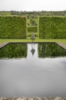 Naked male sculpture squatting above a reflecting pool in the bronze garden at Yeo Valley Organic Garden, May
