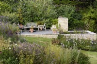 Purbeck stone platform and pond in a country garden in July
