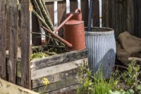 Watering can, small wooden compost bin and water barrel in vintage style
