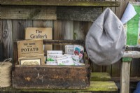 Antique wooden box in a garden shed containing vintage gardening books and seeds bags
