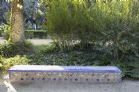A low, colourful glazed tile bench. Parque de Maria Luisa, Seville, Spain. September