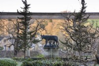 Statue of Romulus and Remus being suckled by the wolf framed by the colonnade on the Great Terrace at Iford Manor in January