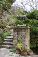 Bronze statue of deer on a stone plinth at Iford Manor in January