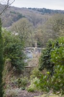 View down to the statue of Britannia on a bridge over the River Frome from Iford Manor in January