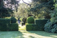 Clipped yew hedges frame a view through the garden at The Manor, Little Compton.