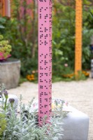 Pink post with sentences in braille in The RHS and Eastern Eye Garden of Unity. Designer: Manoj Malde, May