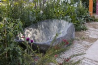  Large polished stone seat surrounded by perennial bed
