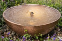 Circular copper water feature with bubble fountain. Designer Penelope Hill Smith - The Wilton London Botanical Fragrance Garden - RHS Hampton Court Palace Garden Festival.