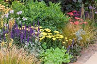 Bed with perennials and grasses, Euphorbia, Anemanthele lessoniana, Achillea, Pennisetum 