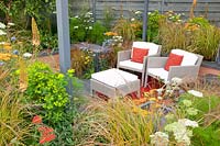Seating area in the sunken garden with perennials, Achillea Terracotta, Anemanthele lessoniana, Allium caeruleum Azureum, Euphorbia walichii, Eryngium Saphire Blue 