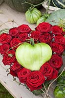 Arrangement with red roses and oxheart tomatoes, Solanum lycopersicum Coer de Boef 