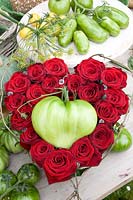 Arrangement with red roses and oxheart tomatoes, Solanum lycopersicum Coer de Boef 