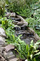 Small stream made of prefabricated elements with hart's tongue fern, Asplenium scolopendrium 