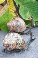 Snails made of bronze and real, polished snail shells 