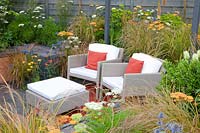 Seating area with perennials, Achillea Terracotta, Anemanthele lessoniana, Allium caeruleum Azureum, Euphorbia walichii, Eryngium Saphire Blue 