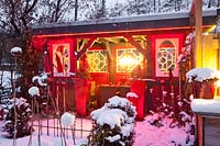 Snow-covered garden house with lighting 