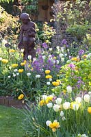Sculpture surrounded by Tulipa Yellow Pomponette, Tulipa viridiflora Spring Green, Tulipa White Heart, Lunaria annua 