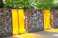 Privacy screen made of logs and colored plastic 