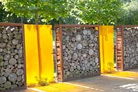Privacy screen made of logs and colored plastic 