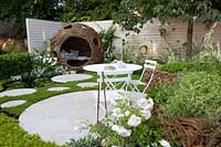 Willow arbor and terrace in a small garden with pond and running chamomile as a lawn substitute, Chamaemelum nobile 