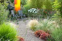 Modern gravel garden with Plexiglas object, Nasella tenuissima, Heuchera Marmalade 