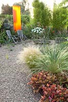 Modern gravel garden with Plexiglas object, Nasella tenuissima, Heuchera Marmalade 