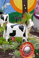 Cow made by children from recycled materials such as tin cans and plastic canisters 