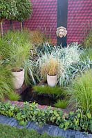 Small garden with water basin and grasses 
