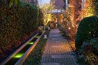 Light in the garden, illuminated path and water basin at the house 