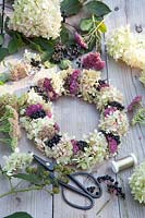 Wreath with ingredients, flowers of Hydrangea paniculata Limelight, Sedum Herbstfreude, Sedum Mr. Goodbud 