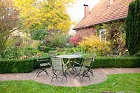 Country garden with seating area in October, Corylopsis pauciflora 