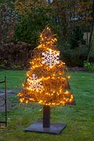 Illuminated Christmas tree made of wooden slats 