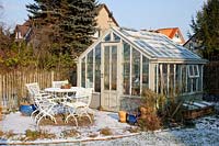 Seating area in front of greenhouse in winter 