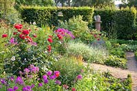 Country garden with hedges, perennials and roses 