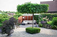Modern garden with lounge furniture and hanging umbrella 